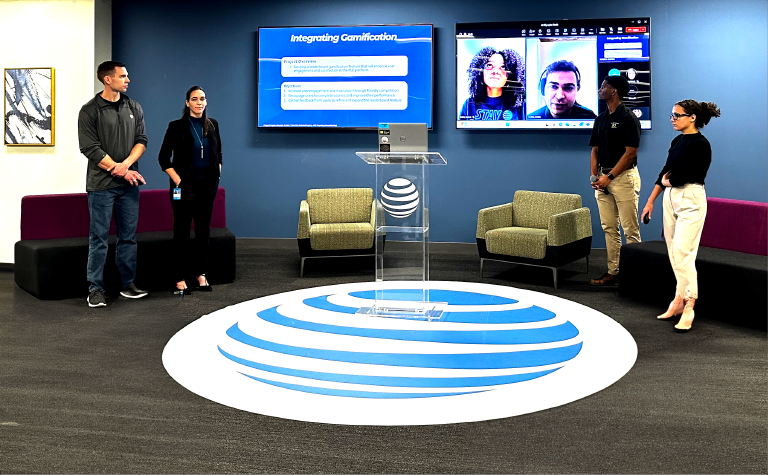 The winning team, PLEdge of Progress, comprises team members from the left: Brian Bell (in person), Serena McMurdie (in person), Bria Whitt (on screen), Owen Florin (on screen), Cole Jarreau (in person), and Caroline Aboff (in person).