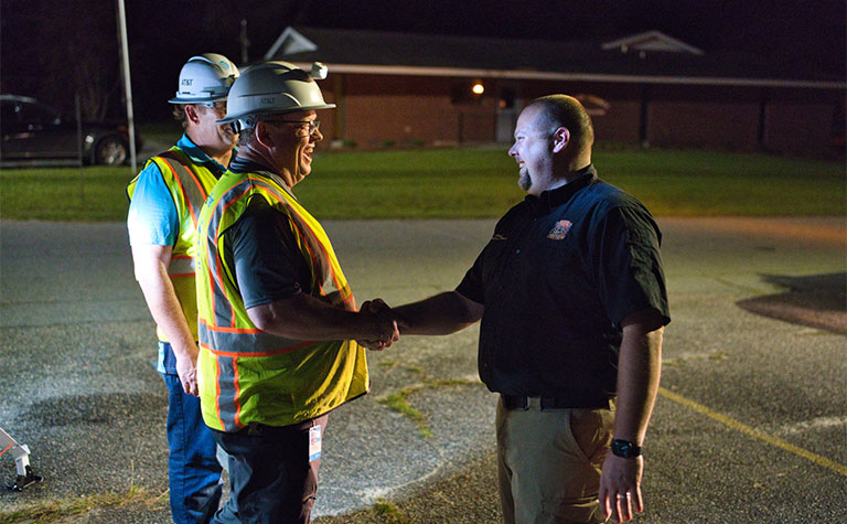 AT&T disaster response team members speak with the Chief of Houston County Fire Department after setting up FirstNet Compact Rapid Deployable (CRD) in Wheeler County, GA.